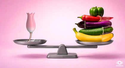 Balance scale comparing OTouch personal massagers against phallic-shaped vegetables and fruits on a pink background.