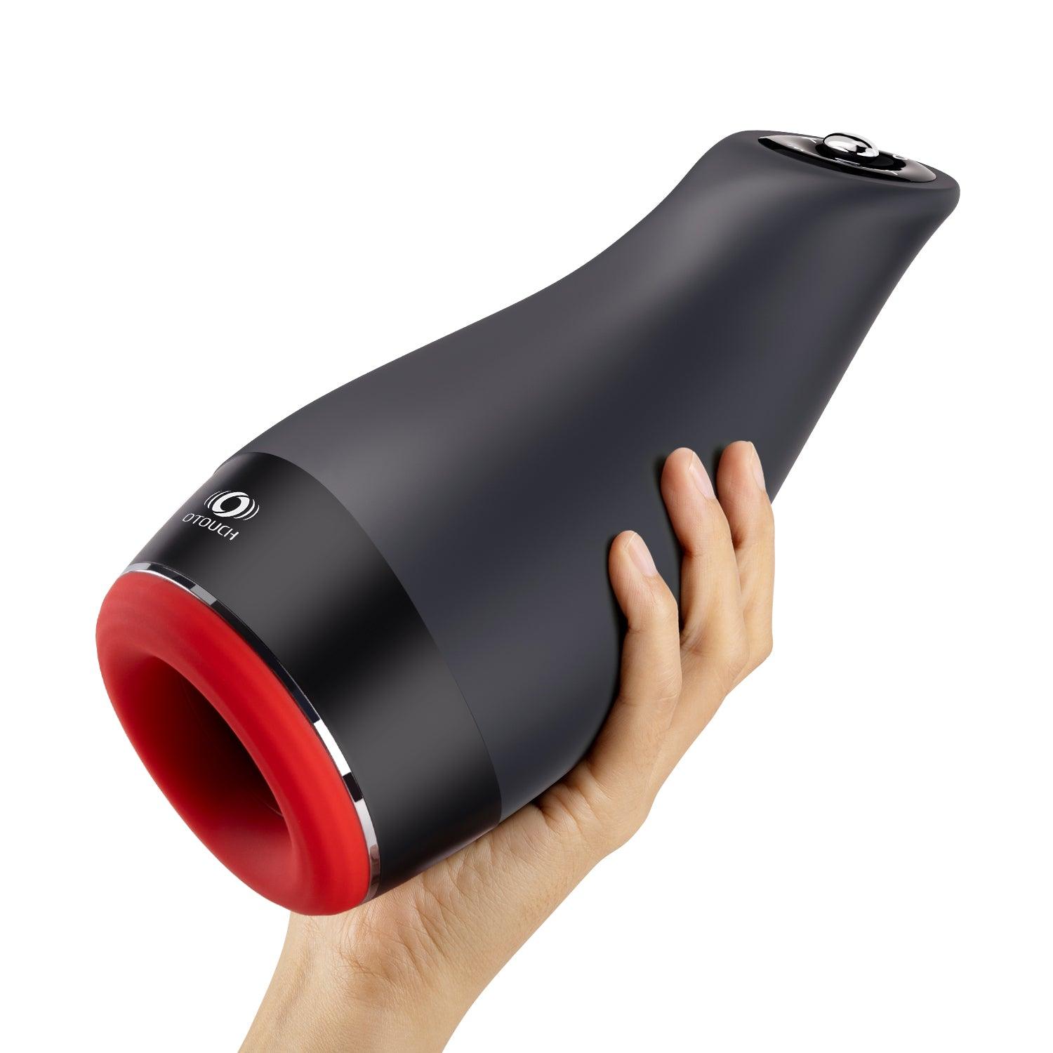 OTOUCH Pleasure Engine auto thrusting vibrating heating male masturbator held in hand showing full ergonomic size and red silicone opening