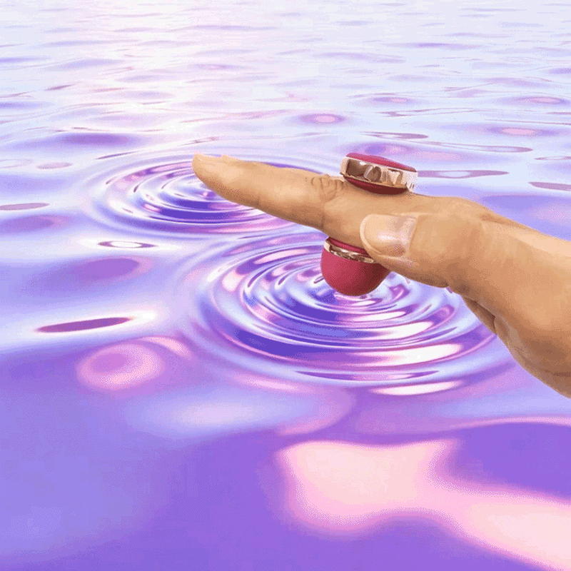 OTOUCH YU fingertip vibrator in use – finger wearing U-shaped vibrator touching water surface